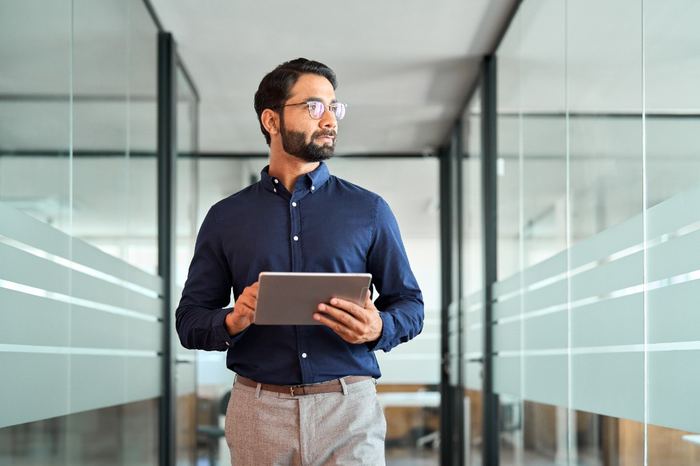 Professionnel examinant une stratégie sur tablette dans un bureau moderne
